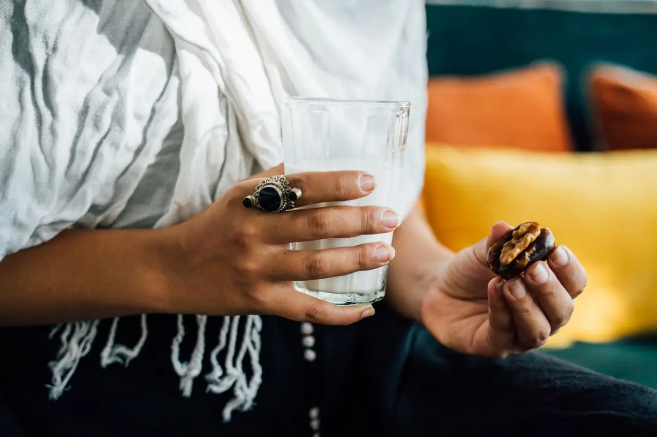 bedroom-bliss A close-up image showing hands holding a glass of milk and a date, symbolizing Iftar.